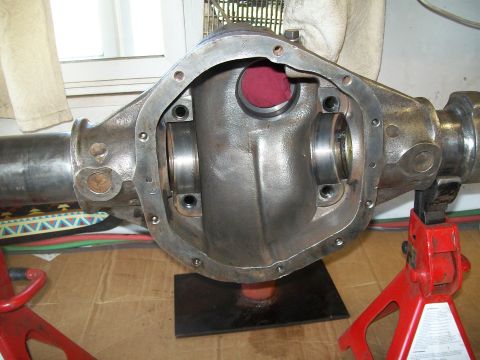1991 Ford Bronco - A close-up view of the differential housing of a vehicle, supported by red jack stands. The housing is open, revealing internal components…