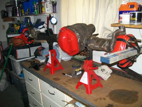 1991 Ford Bronco - A Ford Bronco rear differential assembly is mounted on red jack stands on a workbench. A dial indicator is attached to the assembly, and a…