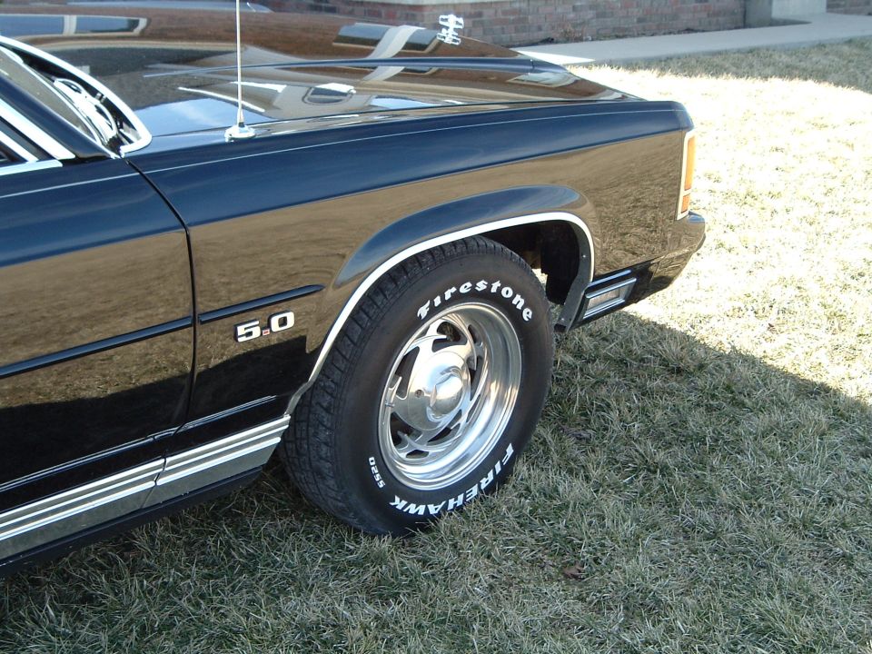 Front wheel and 5.0 fender of black car, polished alloy with Firehawk tire