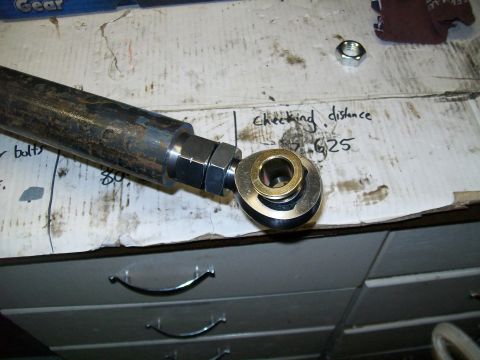 1991 Ford Bronco - A close-up view of a metal rod with a joint assembly attached to one end. Handwritten text on the surface reads "checking distance" and "62…