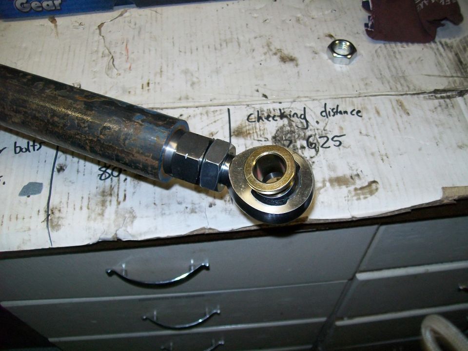 Metal rod with a joint assembly and handwritten notes on a workbench.