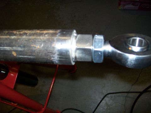 1991 Ford Bronco - A close-up view shows a metal rod with a spherical bearing end attached with nuts. The rod appears to be part of a suspension or steering c…