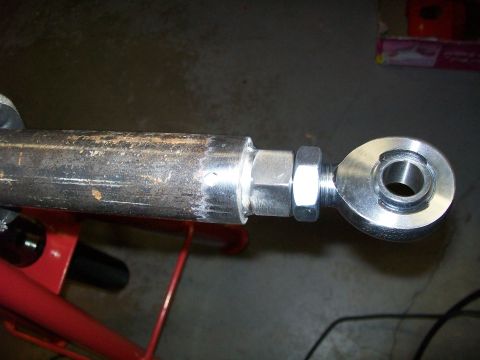 1991 Ford Bronco - A close-up view shows a metal rod with a threaded end connected to a spherical bearing with a nut. The rod appears to be part of a suspensi…