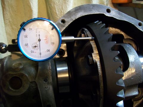 1991 Ford Bronco - A dial indicator gauge is positioned to measure the backlash on a differential ring gear within a vehicle's drivetrain housing. The gauge h…