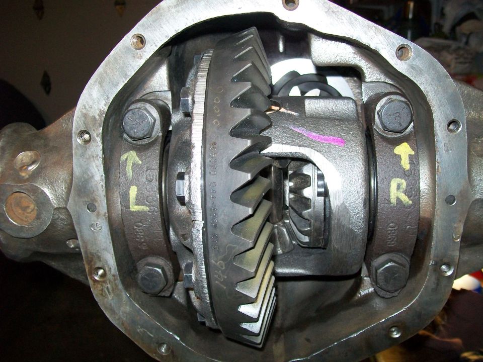 Close-up of differential gears in an open rear axle housing.