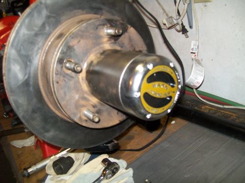 1991 Ford Bronco - A close-up view of a vehicle's front wheel hub assembly, featuring a brake rotor and a Warn locking hub with yellow and black branding. Too…