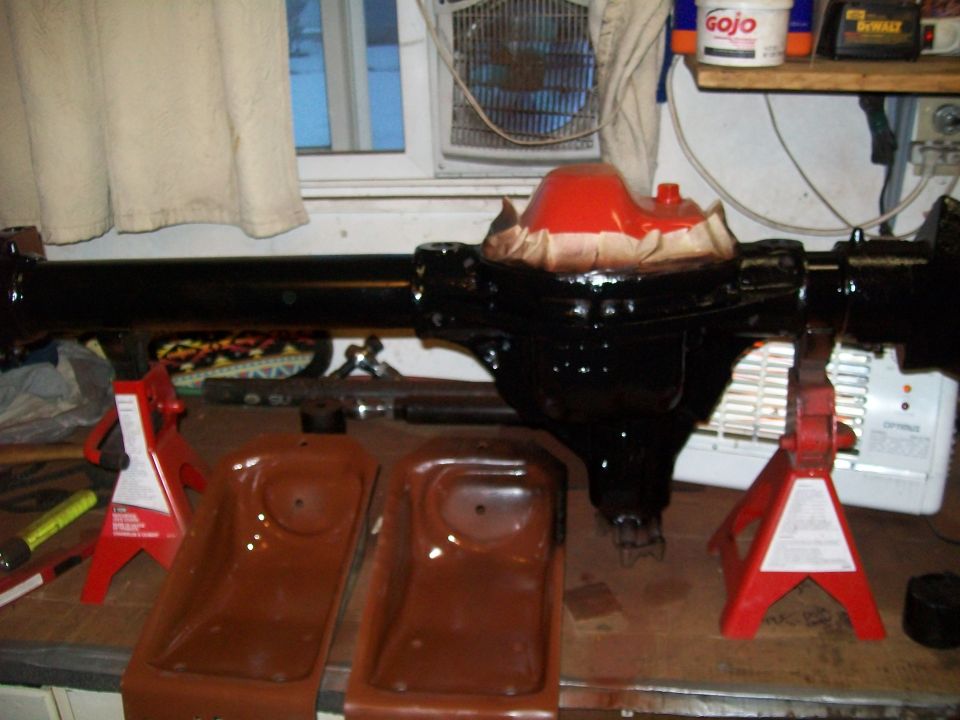 Black rear axle assembly on red jack stands with differential housing.