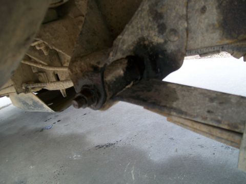 1991 Ford Bronco - This is an underside view of a vehicle's suspension system, showing a leaf spring assembly attached to the frame with a bolt and bracket. T…