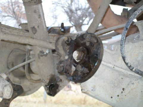 1991 Ford Bronco - A close-up view of the rear axle assembly of a 1991 Ford Bronco, showing the leaf spring and a u-bolt plate with a hub assembly attached.