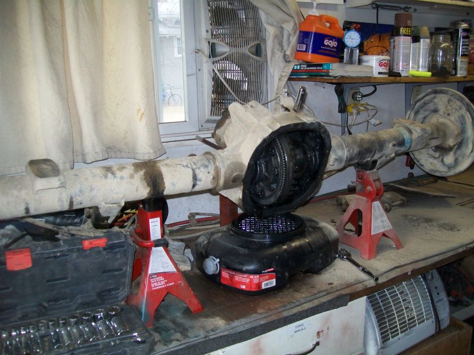 Disassembled rear axle assembly on jack stands with differential open.