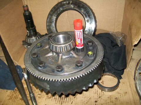 1991 Ford Bronco - A differential gear assembly is laid out on a cardboard surface, with a pinion gear and bearing assembly visible to the left. A tube of Loc…