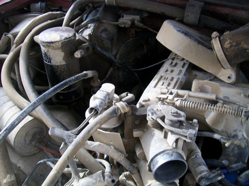 Engine parts, possibly from a Ford Bronco, in a pile