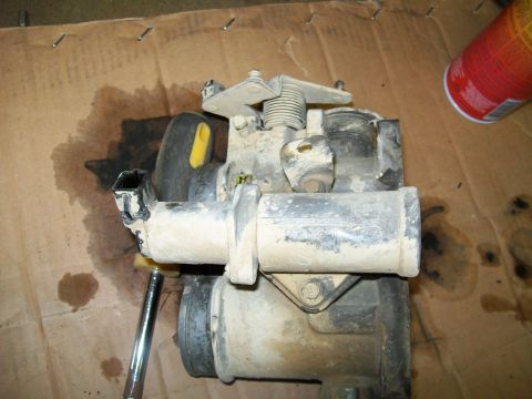 1991 Ford Bronco - A disassembled carburetor is shown, with various parts laid out.