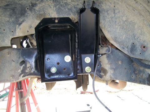 1991 Ford Bronco - Close-up of a suspension bracket and brake line installation on a vehicle frame.