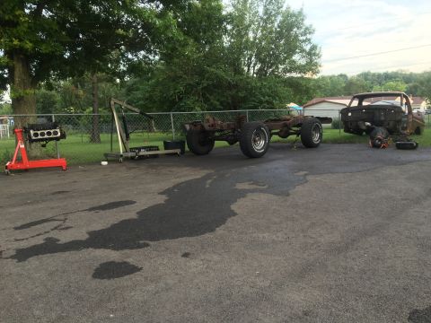 1979 Ford Bronco - A disassembled vehicle sits in a yard with its chassis and cab separated.