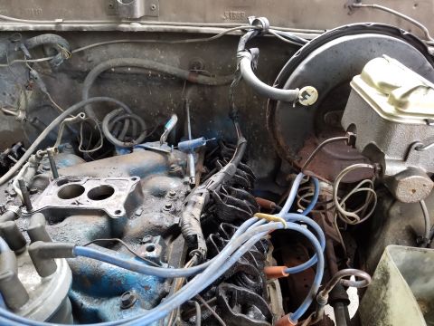 1979 Ford Bronco - A close-up view of a vehicle's engine bay shows various components and wiring.