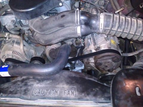 1996 Ford Bronco - Close-up view of the engine compartment, showing various components and a caution fan warning.