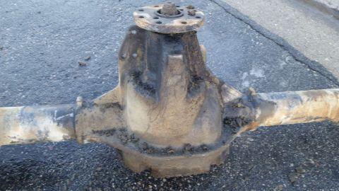 1992 Ford Bronco - This heavily used axle assembly is shown resting on asphalt, with visible dirt and grime.