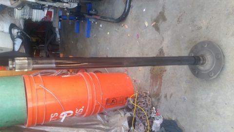 1992 Ford Bronco - An axle shaft is shown lying on the ground next to some buckets and chains.