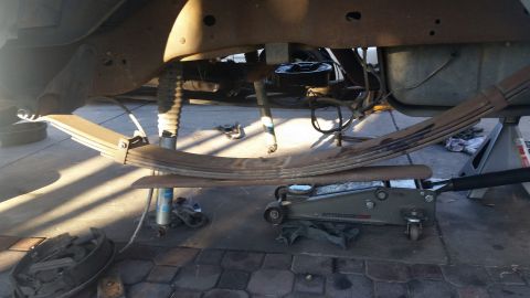 1992 Ford Bronco - Leaf spring suspension work in progress, showing the leaf springs and brake drum.