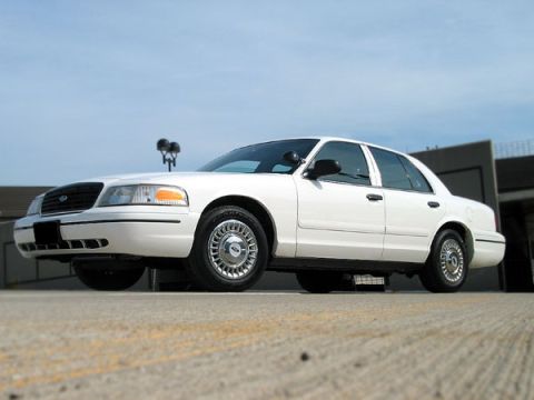 2000 Ford Crown Victoria - A white 2000 Ford Crown Victoria is shown from the front 3/4 angle against a blue sky.