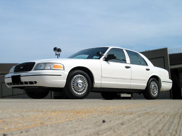 White 2000 Ford Crown Victoria, front 3/4 view, parked on concrete