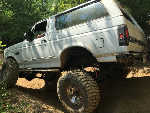 1989 Ford Bronco - This lifted 1989 Ford Bronco navigates a dirt trail, its off-road capabilities.