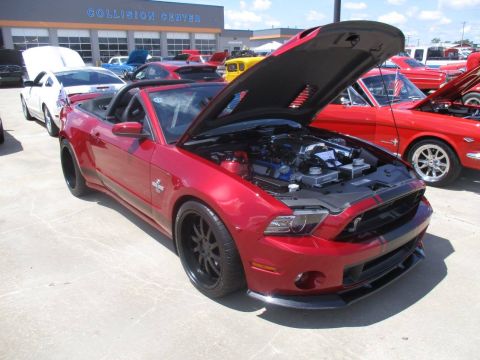 2004 Ford Crown Victoria - Red convertible Mustang with hood open at a car show, parked next to a classic Mustang.