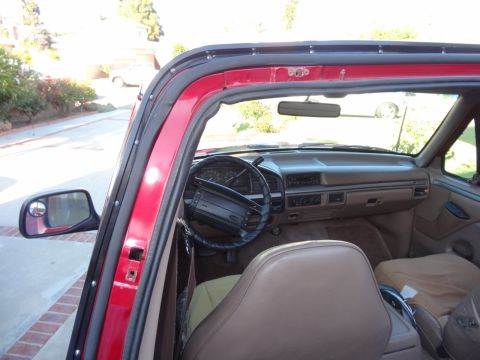 1994 Ford Bronco - Interior view of a red SUV, showing the dashboard, steering wheel, and seats.