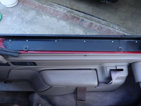 1994 Ford Bronco - Close-up of the interior door panel and seatbelt mechanism in a 1994 Ford Bronco.