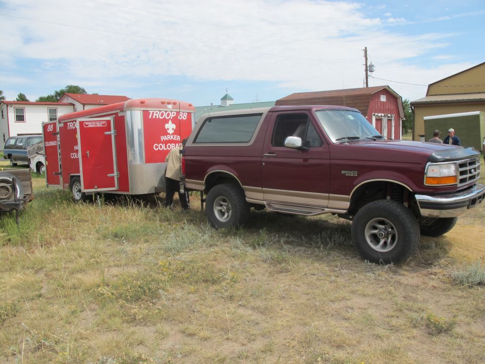 Maroon 1996 Ford Bronco towing a red trailer with "TROOP 88 PARKER COLORADO" on the side