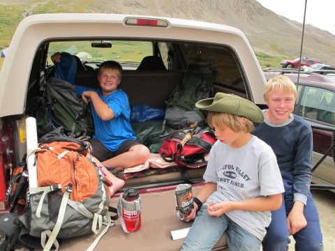 1996 Ford Bronco - Three boys are in the back of a 1996 Ford Bronco, surrounded by camping gear.