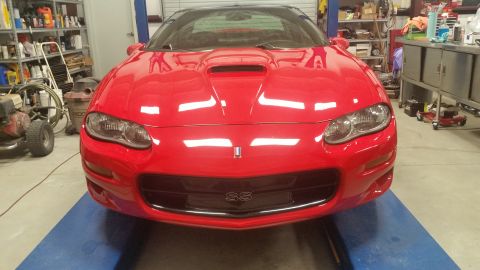 1980 Pontiac Trans Am - Front view of a red Chevrolet Camaro SS in a garage setting.