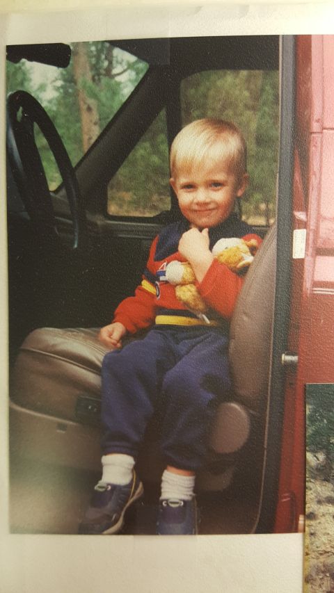 1996 Ford Bronco - A young child sits in the passenger seat of a vehicle, holding a stuffed toy.