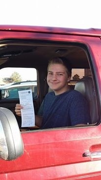 1996 Ford Bronco - Man sits in the interior of a red vehicle, holding a document.