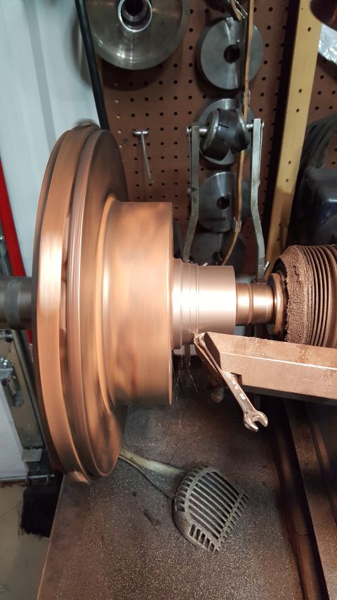 1973 Ford F-100 - A large copper impeller is being machined on a lathe. Metal shavings are visible on the machine bed.