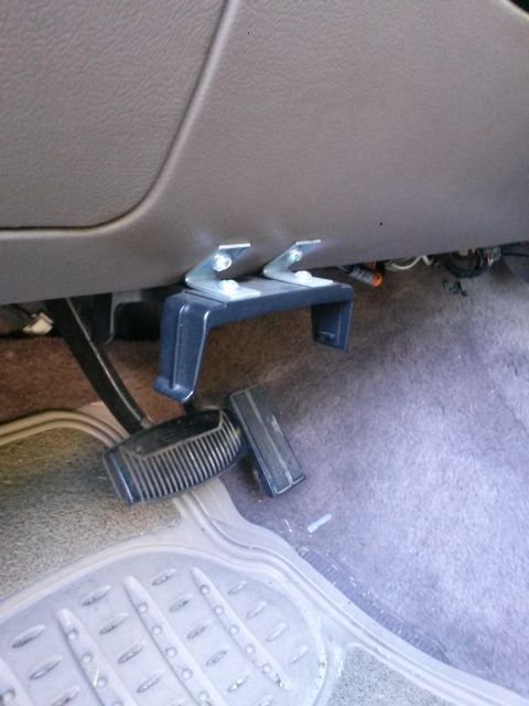 1996 Ford Bronco - A custom-made pedal extender is mounted to the underside of the dashboard above the brake and accelerator pedals in a vehicle interior. The…