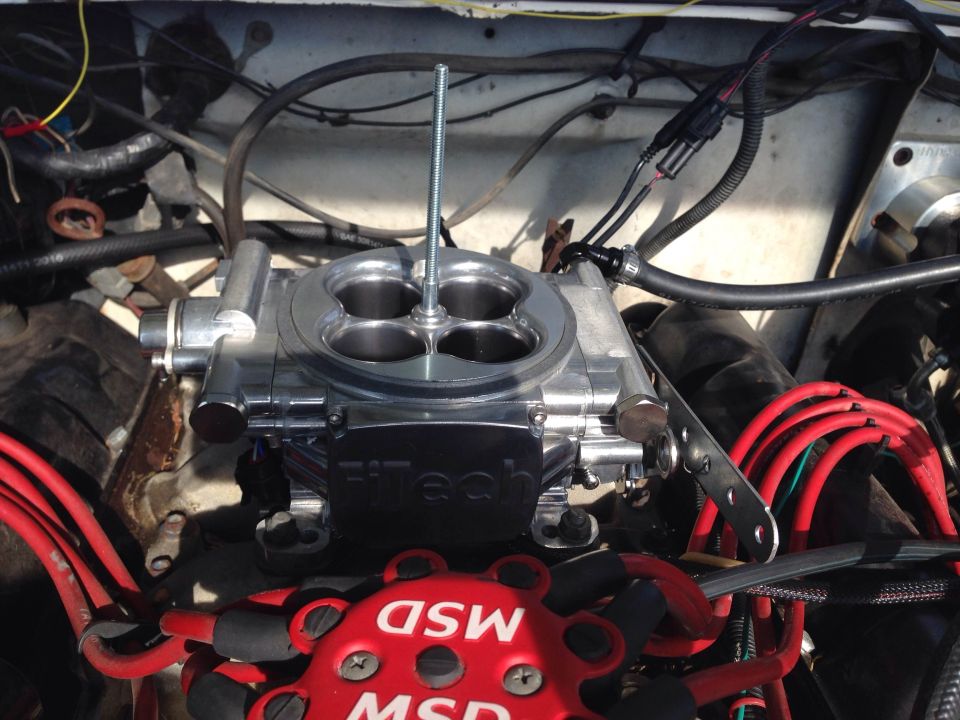 Close-up of a car engine with FiTech fuel injection and red MSD spark plug wires.
