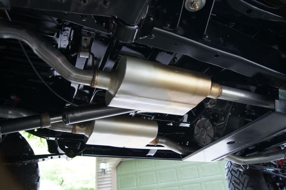 Underside of vehicle showing dual exhaust mufflers and pipes.