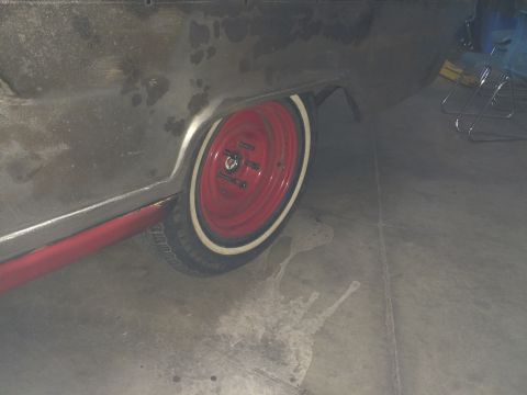 1964 Ford Fairlane - Rear side view of a 1964 Ford Fairlane showing the quarter panel and a red wheel with a whitewall tire.