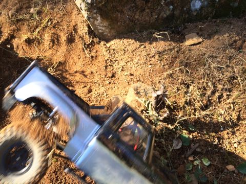 1989 Ford Bronco - A remote-controlled truck navigates a rough, outdoor dirt path.