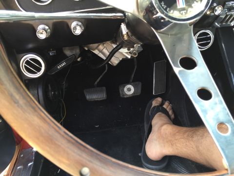 1965 Ford Mustang - Interior view of a 1965 Ford Mustang, focusing on the pedals and steering wheel.