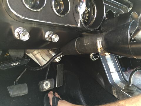 1965 Ford Mustang - Interior view of a 1965 Ford Mustang, focusing on the dashboard, pedals, and steering column.