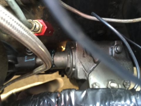 1965 Ford Mustang - A close-up view of a vehicle's steering component, including a red fitting and braided hose, with a SuperMotors watermark.