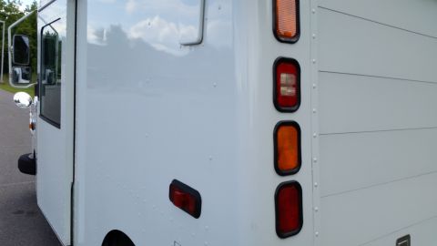 1991 Ford LTD Crown Victoria - The rear section of a white delivery truck shows stacked red and amber lights along its edge.