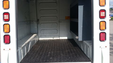 1991 Ford LTD Crown Victoria - Interior view of a cargo van's storage area, a ribbed floor and metal shelving.