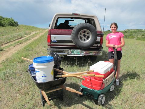 1996 Ford Bronco - A girl stands next to a Ford Bronco loaded with gear, ready for an outdoor activity.