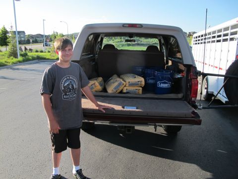 1996 Ford Bronco - A boy stands by the open tailgate of a 1996 Ford Bronco loaded with home improvement supplies.