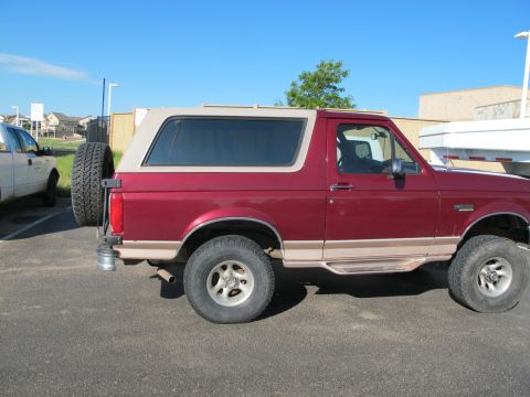1996 Ford Bronco - This 1996 Ford Bronco features a two-tone paint scheme with a removable tan top and a spare tire on the rear.