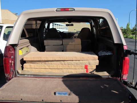 1996 Ford Bronco - Rear view of a 1996 Ford Bronco carrying stacked stone slabs in its cargo area.